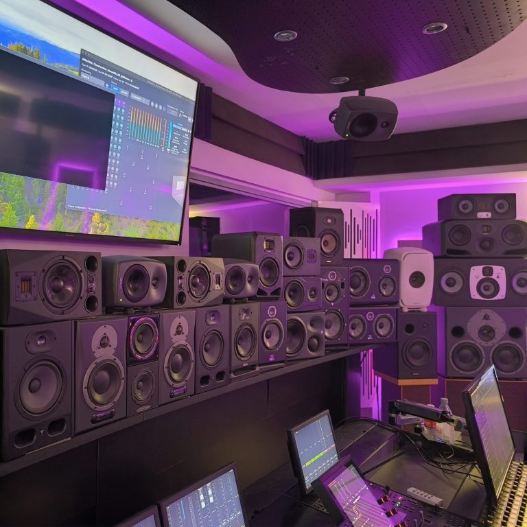 Estudio de grabación con numerosos monitores de audio y equipo de producción musical.
